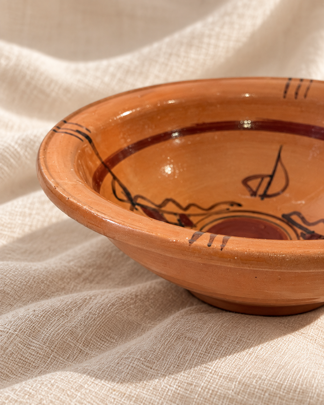 Détail du bol Taqbaylit en terre cuite artisanale avec motifs kabyles peints à la main